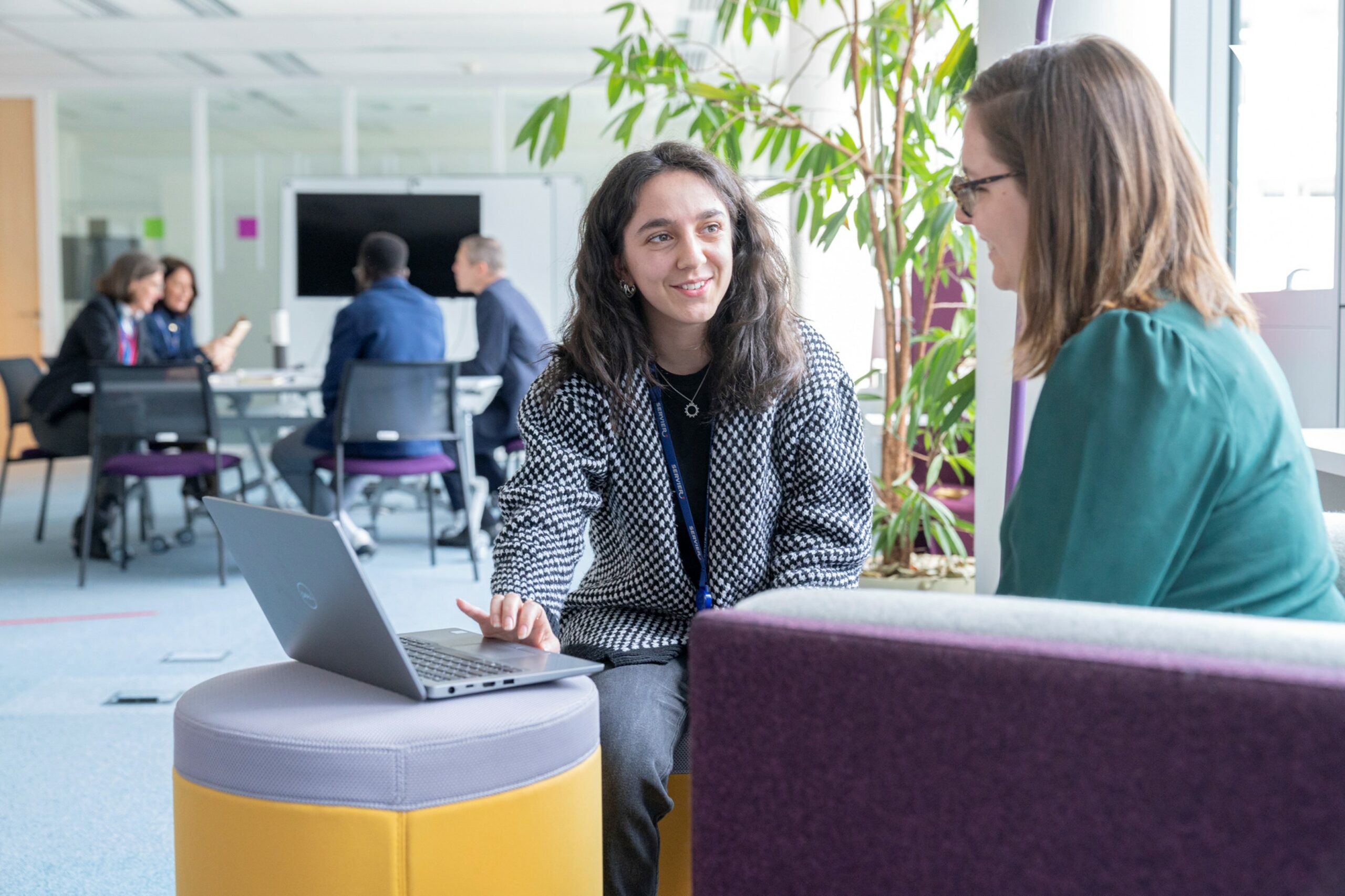 deux femmes discutant face à un ordinateur